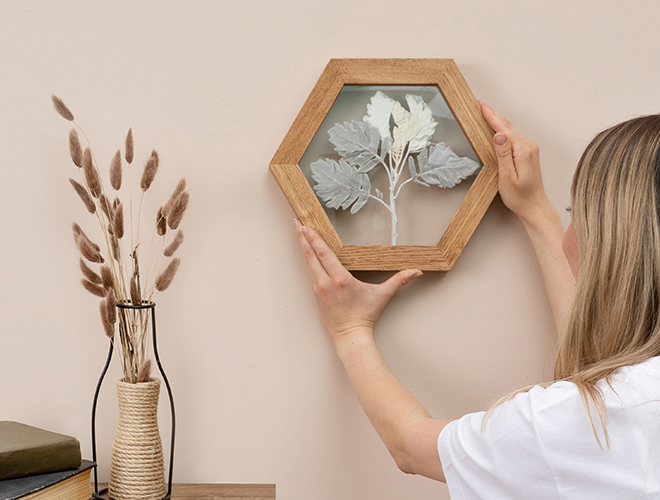 Femme qui accroche des arrangements de fleurs séchées diy