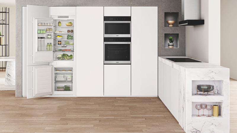 Světlá moderní kuchyně vybavená spotřebiči Whirlpool.