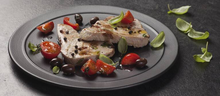 Gegrillte Thunfischscheibe mit Kirschtomaten und Oliven