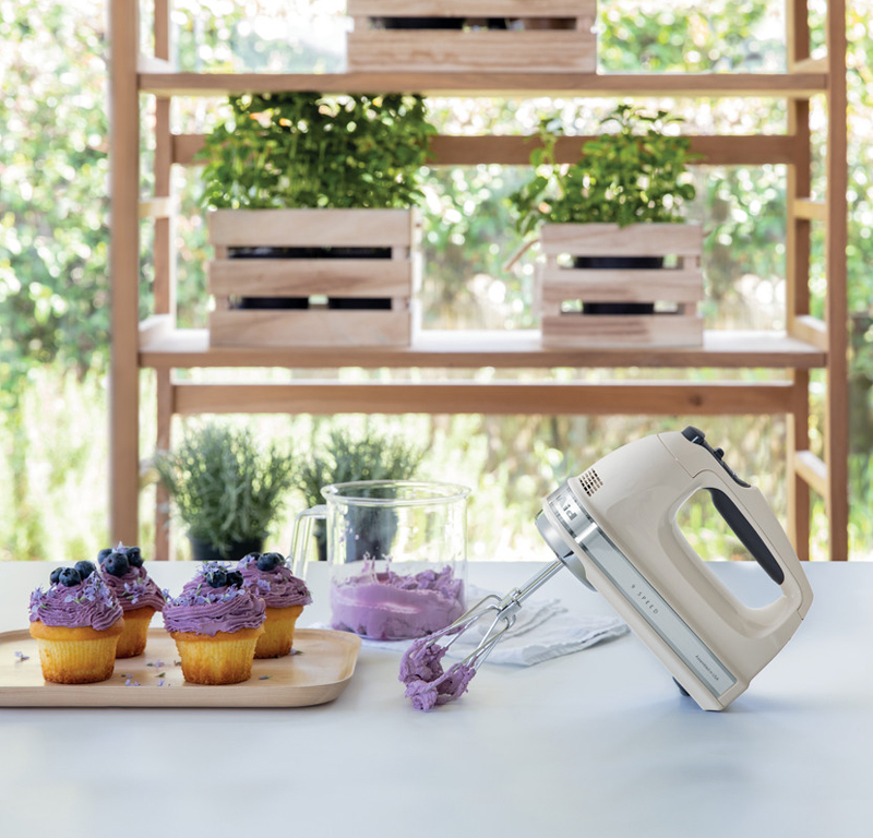 Cream hand mixer and purple cupcake