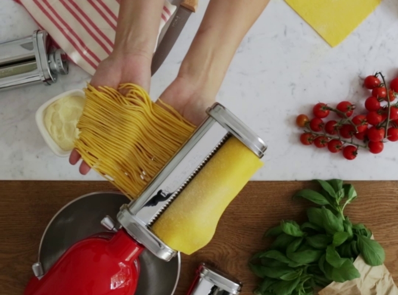 Red stand mixer making linguini with pasta cutter