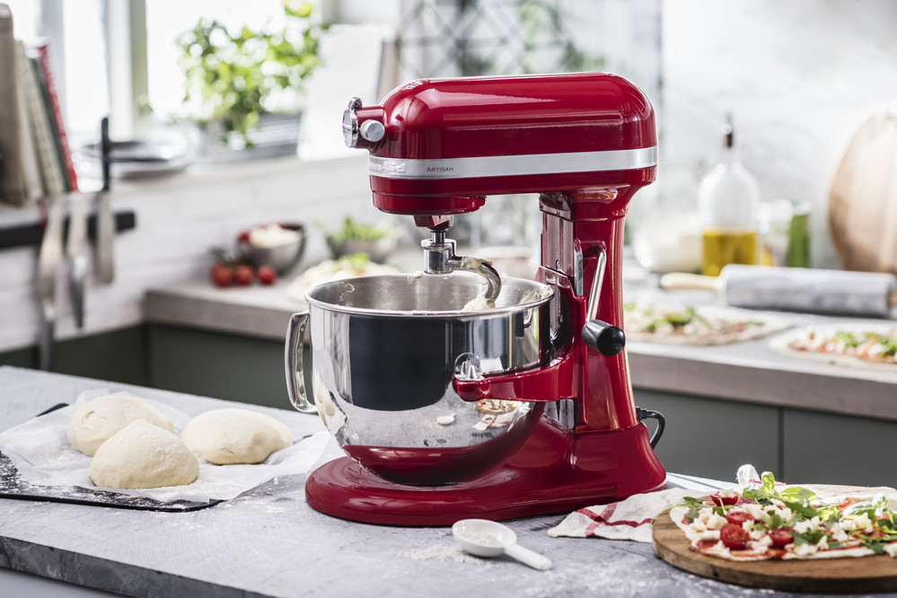 Red stand mixer with dough hook kneading pizza dough