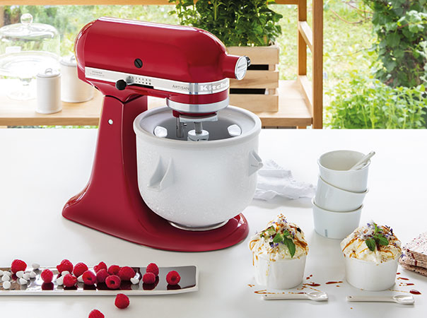 Ice cream maker on red mixer with vanilla ice cream and raspberries