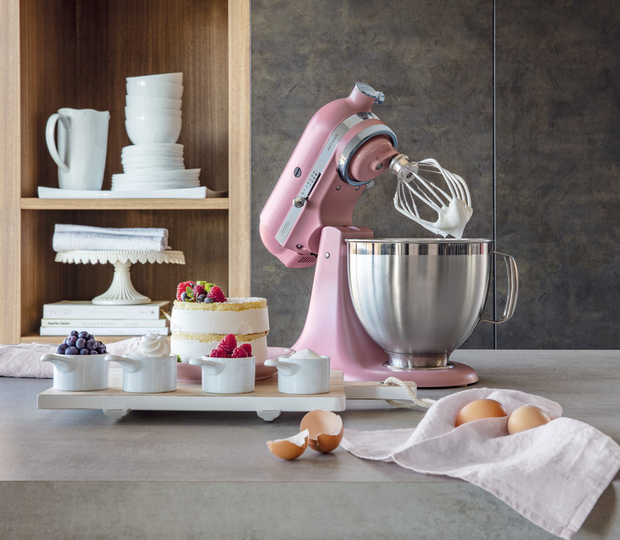 Pink mixer with a whisk whipping cream