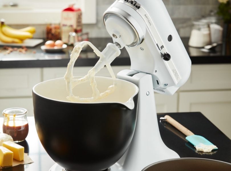 Paddle attachment on white mixer with black mixing bowl