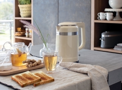 Cream kettle design and cup of ginger tea