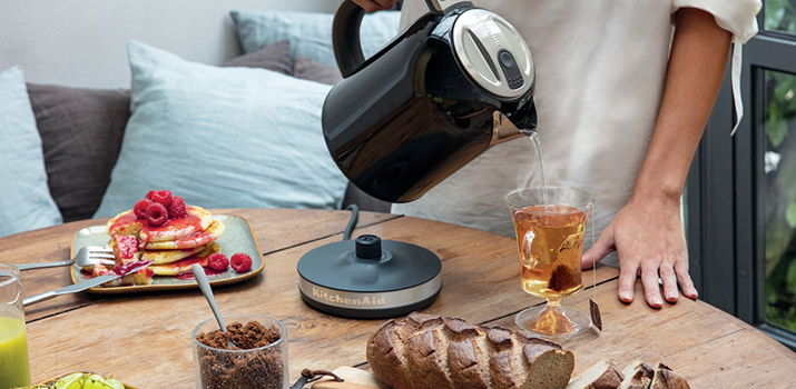 Black kettle with tea and pancakes