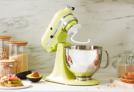 Dough hook on yellow mixer with stainless steel mixing bowl