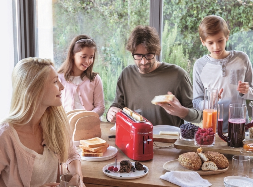 Happy family together enjoying breakfast made with red toaster