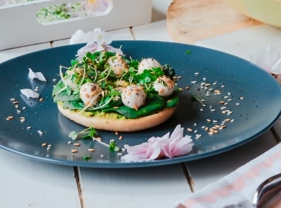 Bagel with rucola on blue plate