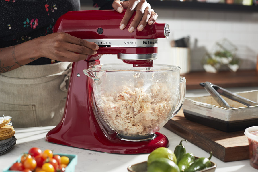 Mixer with paddle attachment shredding cooked chicken