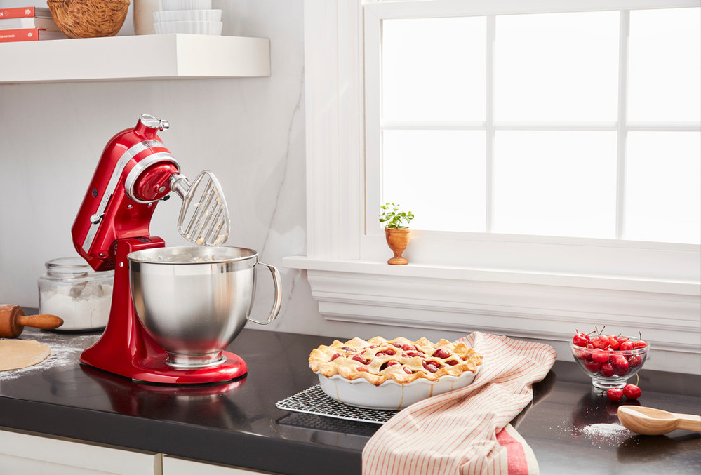 Red stand mixer with pasty beater mixing ingredients for a pie