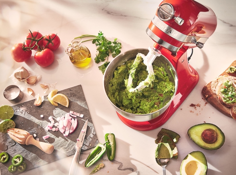 Red mixer preparing guacamole using a flat beater