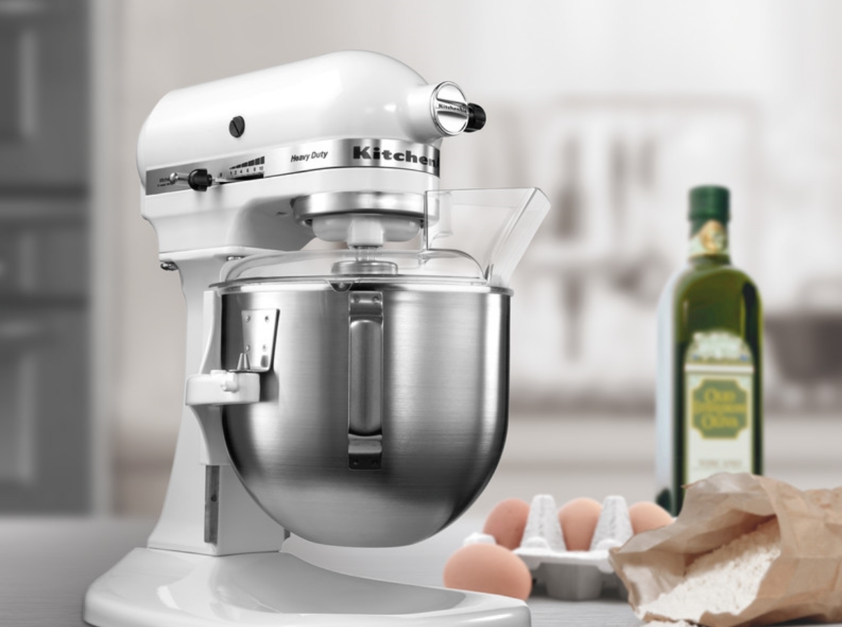 White mixer preparing dough with eggs and flour