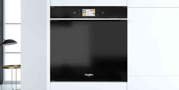 Crna ugradbena Whirlpool pećnica s digitalnim ekranom. Ugrađena u bijelu kuhinju.
